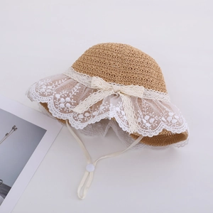 Children's straw sun hat with white lace trim and bow decoration for summer beach