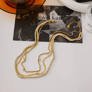 Détail d'un collier 3 rangs en acier doré 18K avec chaîne serpent et pierres de zircon