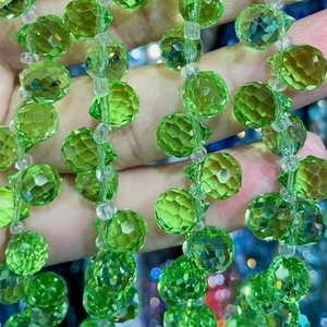 Macro shot of green faceted crystal glass strawberry beads with horizontal drill hole