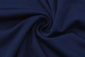 Détail macro du tissu en maille bleu foncé montrant la texture douce et l'élasticité