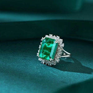 Macro view of emerald-cut green gemstone ring with white zircon halo and silver band
