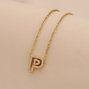 Close-up of golden letter P pendant with sparkling crystals on a delicate chain