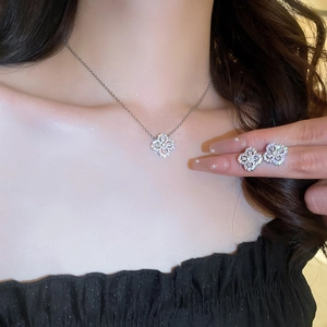 Detail view of the silver clover jewelry set with sparkling zircons on a model's neck