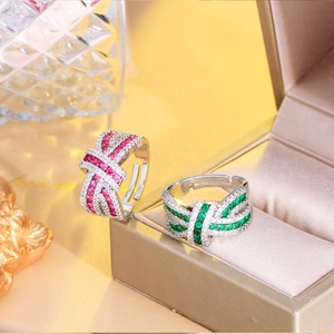 Detailed close-up of crisscross zircon rings with red and green stones in a jewelry box