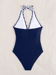 Detail of navy one-piece swimsuit showing white lining and removable circular pads