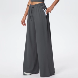Close-up of deep grey athletic wide-leg pants showing functional side pocket with phone