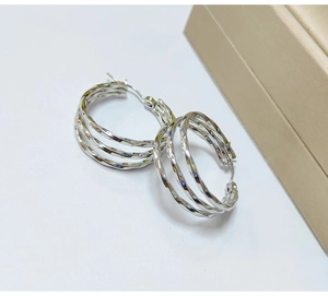 Macro shot of silver multi-layer twisted hoop earrings with a polished metallic finish