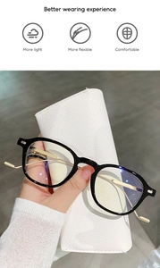 Detail of black frame eyewear with gold metal temples and blue light blocking coating