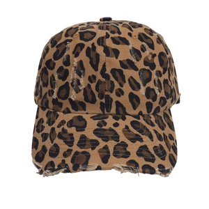 Close-up of distressed vintage leopard print baseball cap with frayed edges and texture