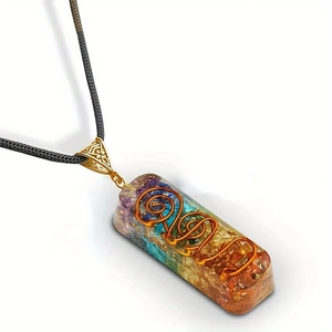 Macro view of Orgone pendant with natural seven chakra stones and copper coil spiral
