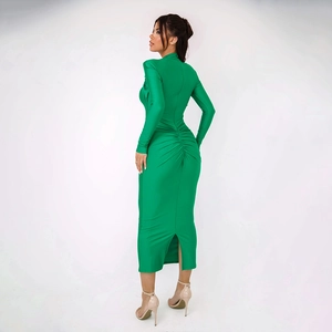 Detail of green bodycon dress featuring waist ruching and a back slit hemline