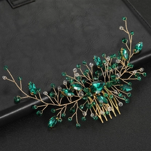 Macro detail of emerald crystal bridal hair comb with gold wire and clear gemstones