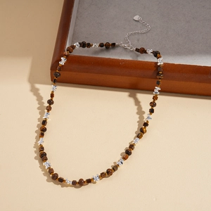 Detail of tiger eye beaded necklace with silver extension chain and heart charm