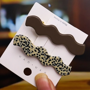 Wavy hair clip set featuring solid brown and leopard print designs on a white card