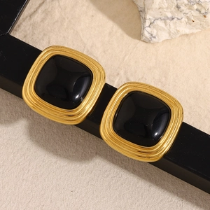 Detailed close-up of 18K gold-plated square stud earrings featuring a black center stone