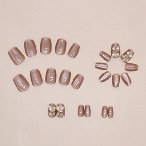 Detail of cat-eye press-on nails with sparkling rhinestones and rose gold finish