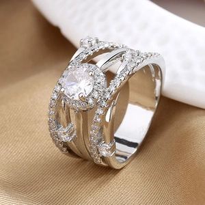 Detailed macro view of silver hollow wide band ring with round center stone and zircon