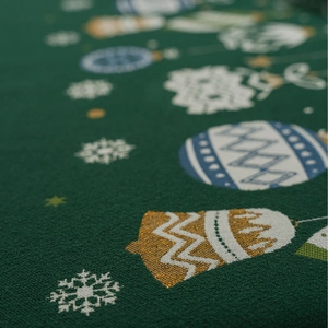 Macro detail of Christmas green table runner featuring festive jacquard snowflake patterns