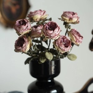 Faux vintage roses in a black ceramic vase for elegant European style home decor