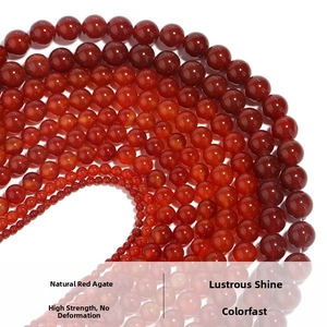 Macro shot of natural red agate round beads in various sizes arranged in a curved line