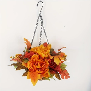 Close-up of fall hanging basket with orange peonies, maple leaves, and berry clusters