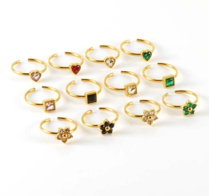 Detail view of adjustable gold-plated rings with colorful heart and flower gemstones