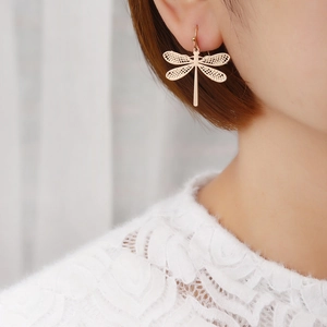 Fashionable rose gold dragonfly earrings with intricate hollow wings worn by a female model