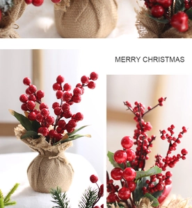 Mini artificial Christmas tree with red berries in burlap bag for office tabletop decor