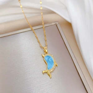 Luxurious gold dolphin necklace with blue enamel and sparkling crystals on white silk