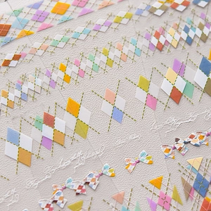Colorful geometric nail art stickers with diamond patterns and bow designs for manicure