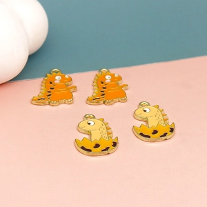Close-up of colorful enamel dinosaur charms in orange and yellow for jewelry making