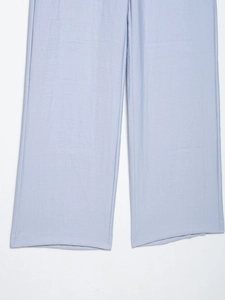 Detailed macro view showing the natural fabric texture of light blue wide leg trousers
