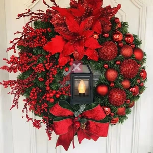 Detail of Christmas wreath with red berries, poinsettia flower, and a glowing black lantern