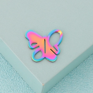 Macro shot of rainbow stainless steel butterfly pendant with cutout design details
