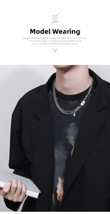 Detail of men layered steel necklace with engraved rectangular tag and small heart charm