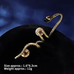 Detailed close-up of vintage gold snake brooch with black bead and scale textures