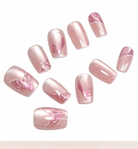 Close-up of pink mermaid tail press-on nails with glitter texture on white background