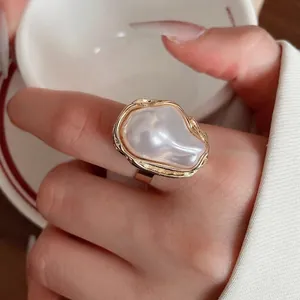 Eleganter goldener doppelter gewellter Ring mit weißem Harzstein für einen modernen Look