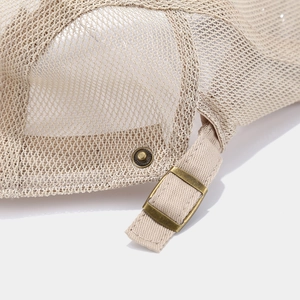 Detail von atmungsaktivem Mesh-Gewebe und Bronze-Schnalle der beigen Schiebermütze