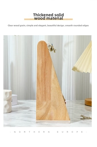 Detail of triangular wooden jewelry stand with metal earrings on marble surface