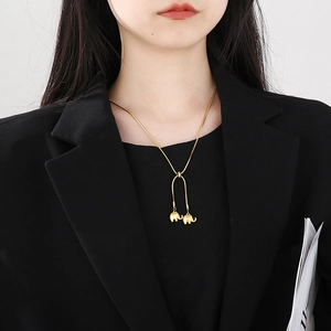 Gold-plated stainless steel snake chain necklace with twin elephant pendants on model