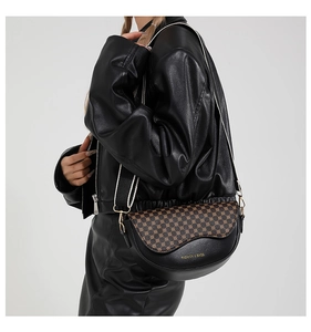 Chic saddle crossbody bag in black and brown leopard print worn by a model