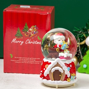 Detailed view of a Christmas snow globe with Santa sleigh and festive gift packaging