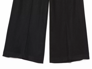 Detailed close-up of black linen blend wide-leg trousers showing woven fabric texture