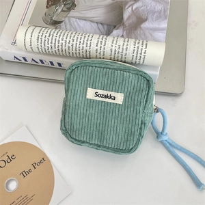 Close-up of green corduroy cosmetic bag showing texture and Sozakka brand label