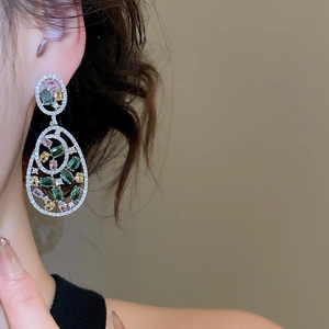 Detail of elegant teardrop earrings with multi-color gemstones and micro-pave crystals