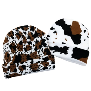Detailed close-up showing the knit texture and cow and leopard print patterns on beanies