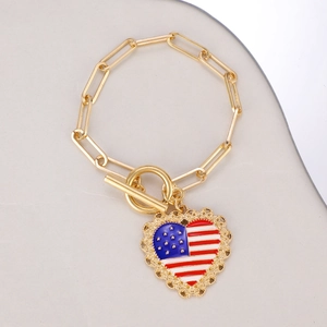 Detail of golden paperclip chain bracelet with heart-shaped American flag pendant and OT clasp