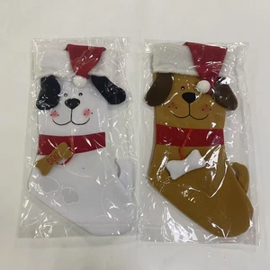 Detail of plush dog Christmas stockings with red hats and decorative bone charms