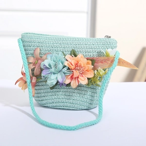 Detail der mintgrünen Strohtasche mit bunten Blumenapplikationen und Reißverschluss oben
